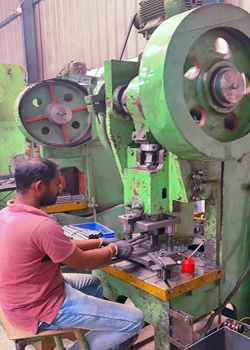 Operator running a green mechanical power press with a press tool at the Karthikeya Engineering shop floor