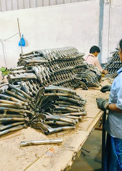 Batch of fabricated tubular components stacked on a work table during inspection and assembly
